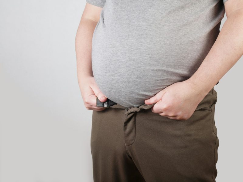 obese man with fat belly doesn´t fit in his trousers anymore