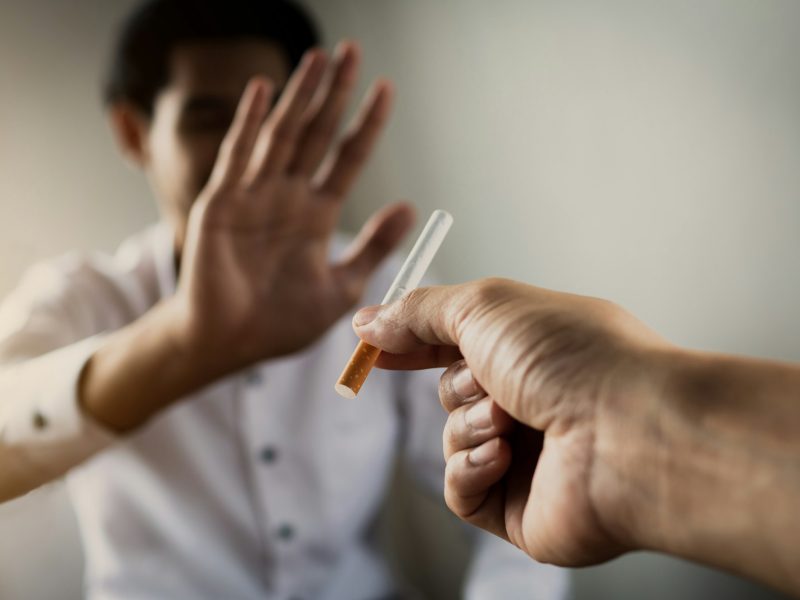 World No Tobacco Day in May, stop smoking concept, young man give cigarette but friend against