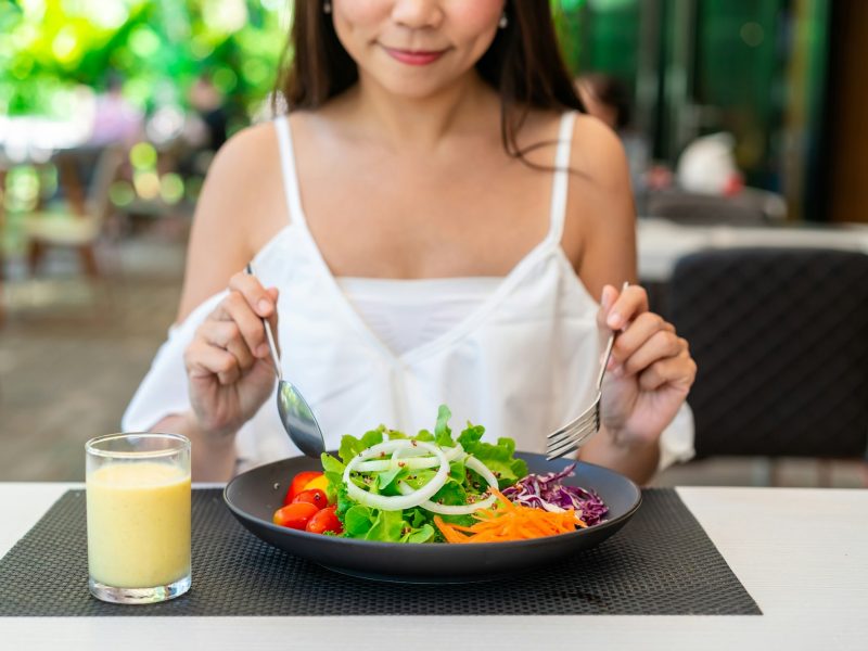 Young woman eating healthy salad at restaurant, Healthy lifestyle and diet concept